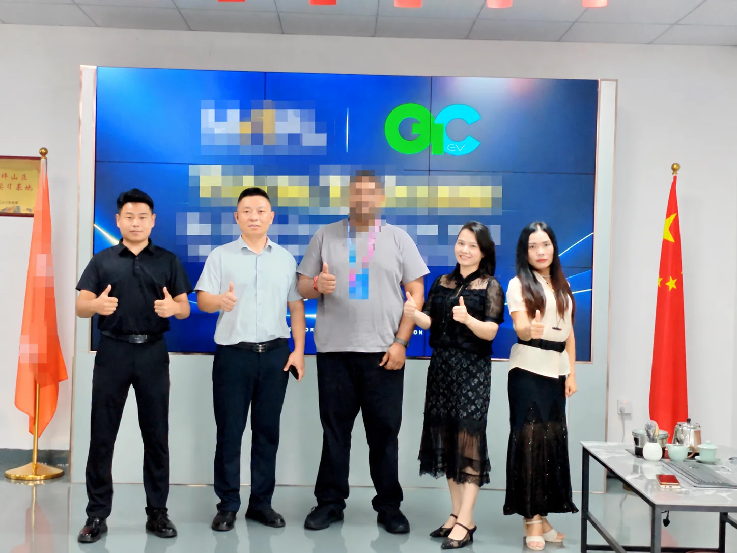 A visitor with identifying details obscured and LiCharger team members after a factory tour